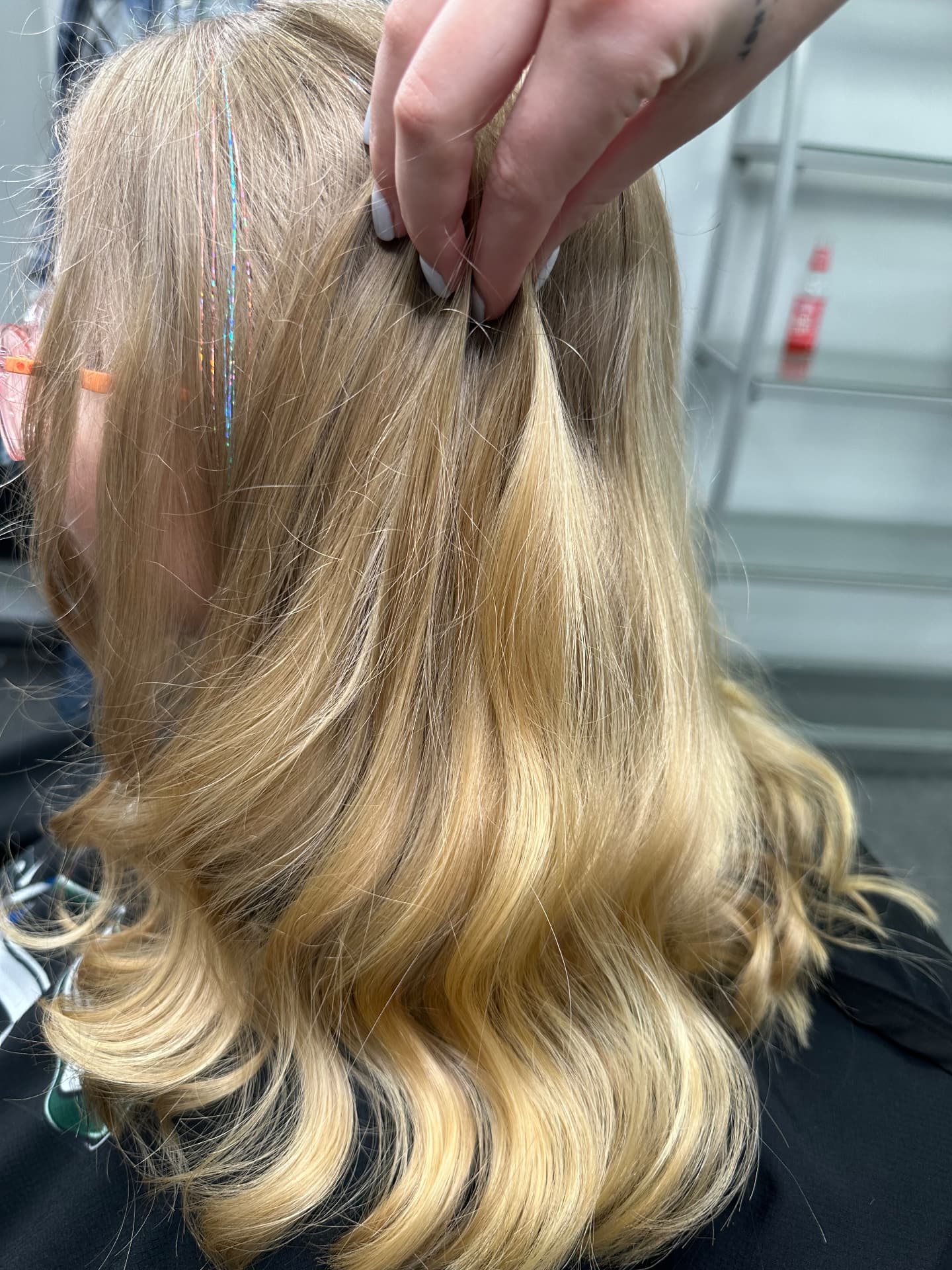 Holographic hair tinsel installed in blonde waves